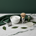 Premium shaving bowl and brush set on marble surface with alum block